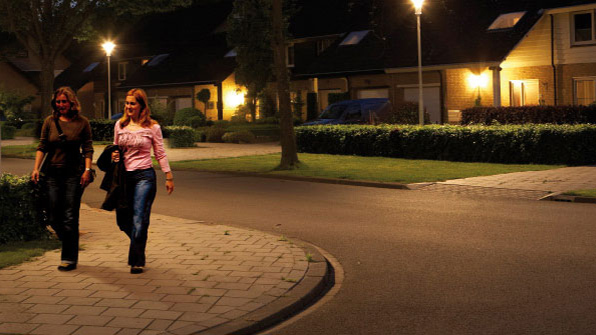 Fußgängerinnen auf einer mit dynamischem Licht von Philips beleuchteten Straße