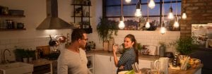 „Moderne Küche mit LED-Hängeleuchten im Vintage-Stil, die zwei Frauen beim Abendessen beleuchten und eine warme, einladende Atmosphäre schaffen.“