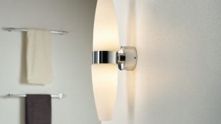 „Modernes Badezimmer mit einer eleganten LED-Wandleuchte, die das minimalistische Dekor beleuchtet und das Spa-Ambiente verstärkt.“